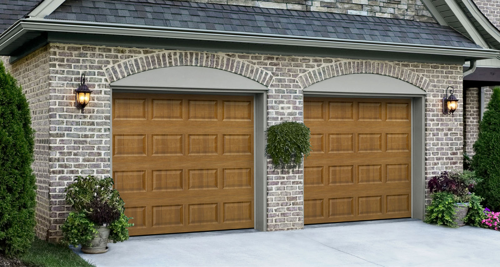 Two single wood garage doors in brick garage front